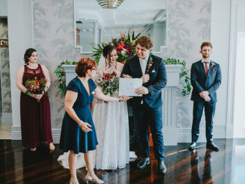 Amanda Medill wedding celebrant handing married couple marriage certificate in Townsville